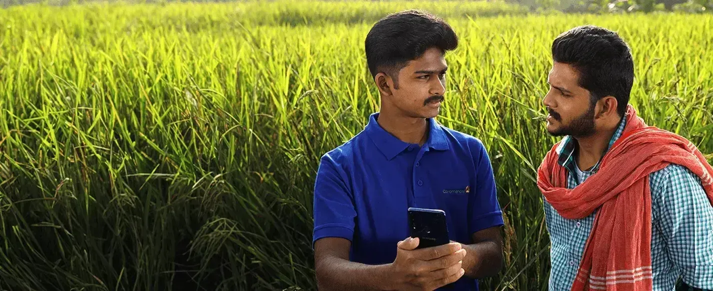 A Coromandel International representative speaking with farmer