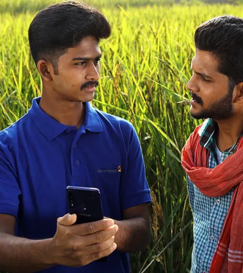 A Coromandel International representative speaking with farmer